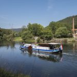 a blue and white boat traveling down a river