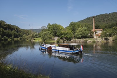 a blue and white boat traveling down a river