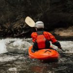 person water rafting on body of water