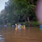 Person kayaking and tubing on a river
